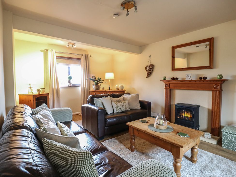 A living room with a sofa and coffee table at Barclay Cottage in Biddenden