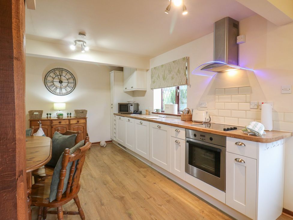 A kitchen with appliances and a dining area at Barclay Cottage in Biddenden