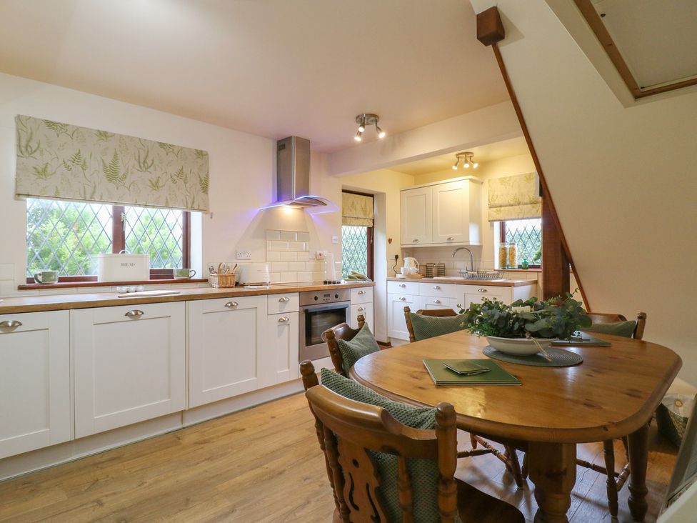 A kitchen with wooden table and chairs at Barclay Cottage in Biddenden