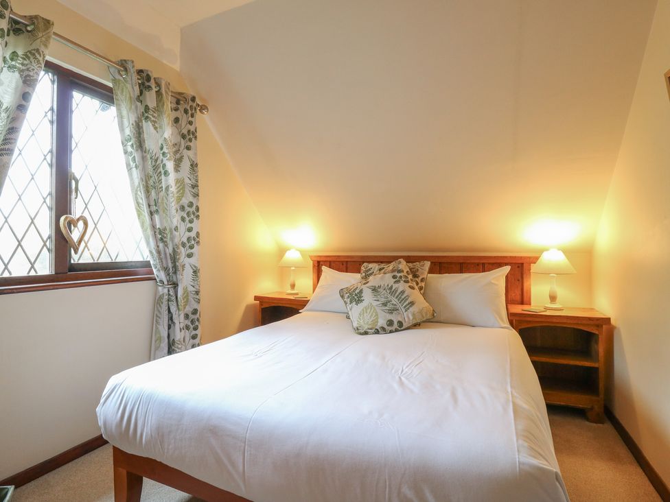 A bedroom with a bed and window at Barclay Cottage in Biddenden
