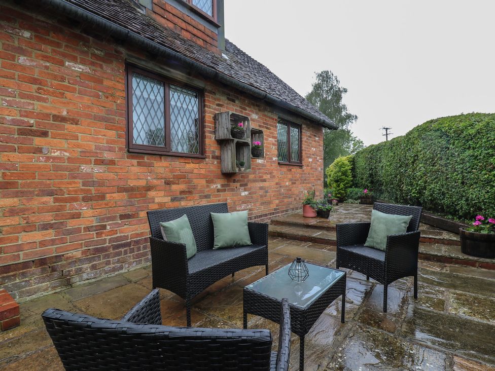 An outdoor seating area with chairs and a table at Barclay Cottage Biddenden