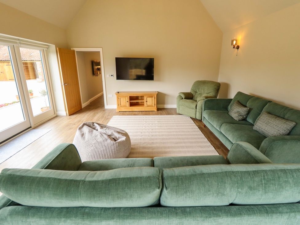 A living room with a sofa and television at Bobblehat Barn Alford