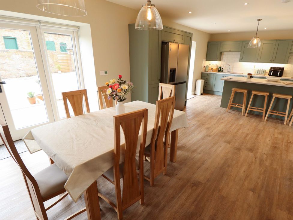 A dining area with a table and chairs at Bobblehat Barn Alford