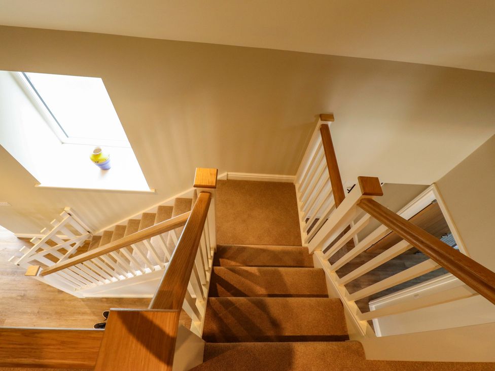 A staircase with a handrail and a window at Bobblehat Barn in Alford