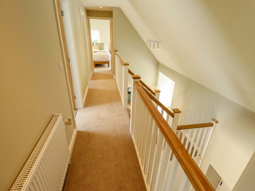 A hallway with doors and railings at Bobblehat Barn in Alford