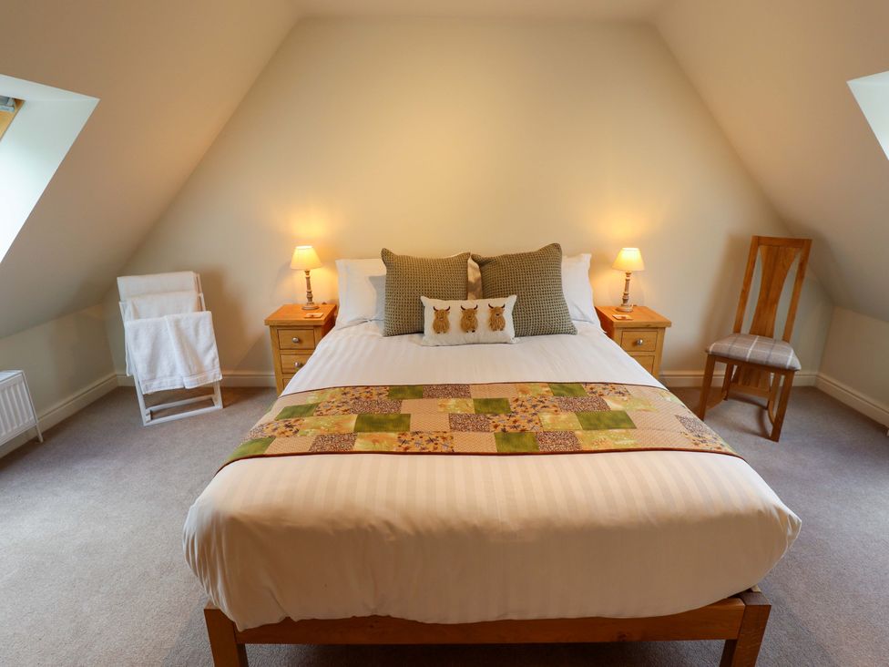 A bedroom with a bed and bedside tables at Bobblehat Barn in Alford