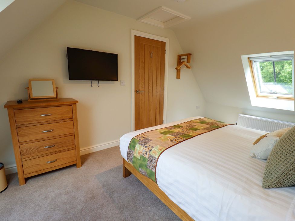 A bedroom with a bed and a television at Bobblehat Barn Alford