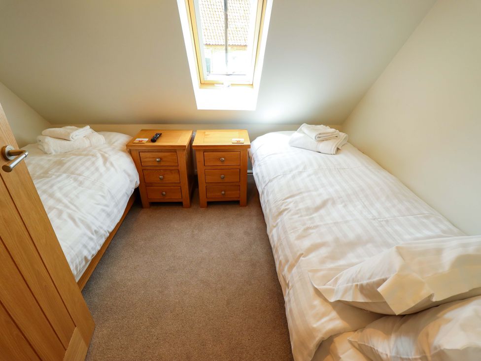 A bedroom with two beds and nightstands at Bobblehat Barn Alford