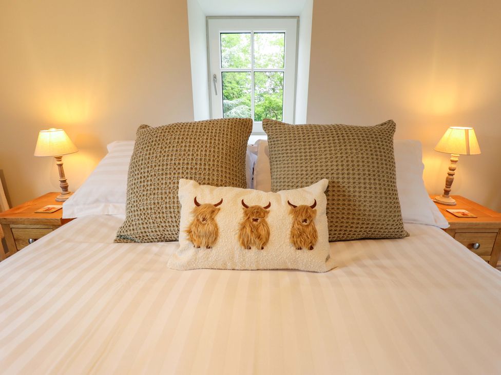 A bedroom with a bed and decorative pillows at Bobblehat Barn in Alford