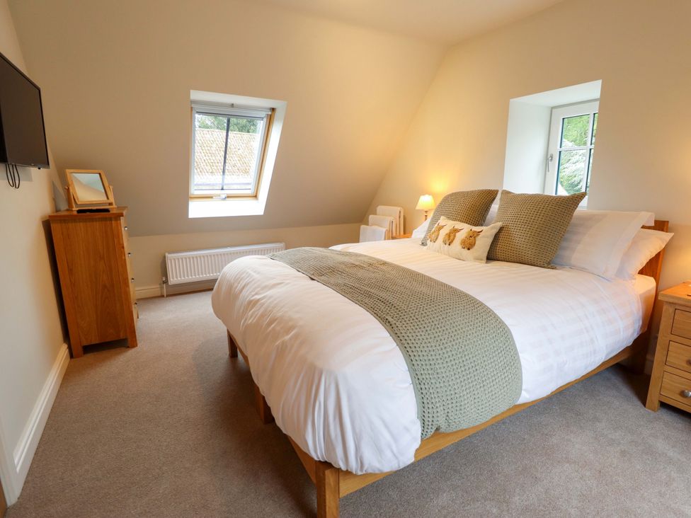 A bedroom with a bed and window at Bobblehat Barn Alford