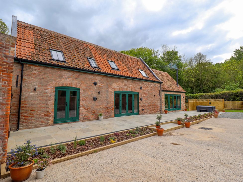 An outdoor view of a building with green doors and windows at Bobblehat Barn in Alford