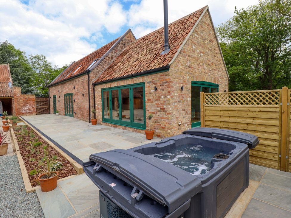 An outdoor area with a hot tub and slate patio at Bobblehat Barn Alford