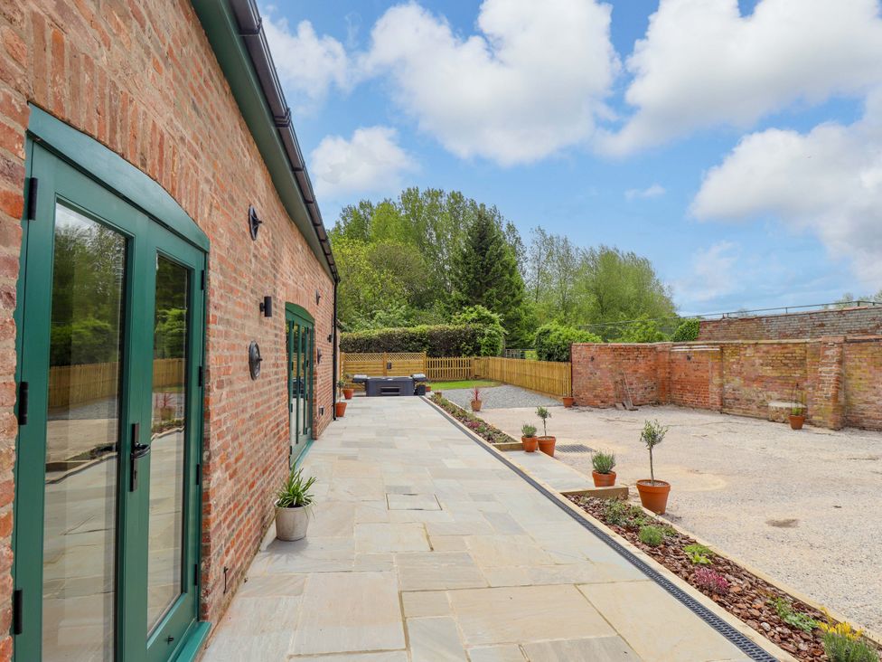 An outdoor area with plants and a patio at Bobblehat Barn in Alford