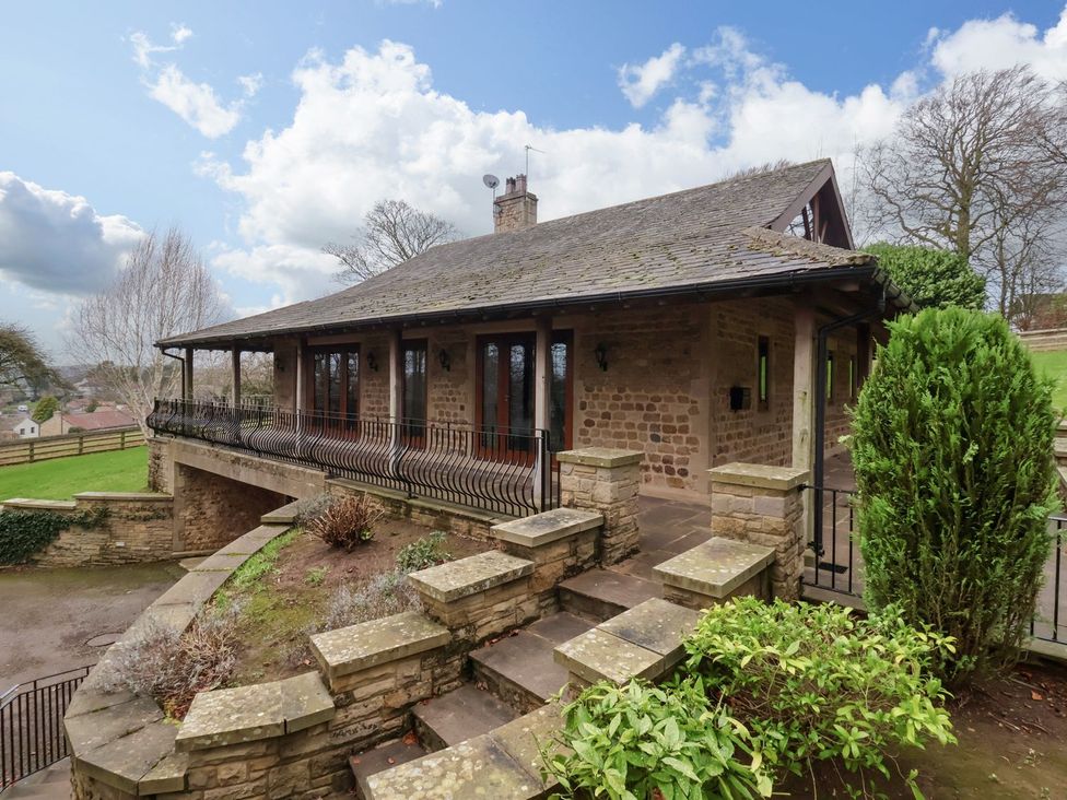 An outdoor area with a house and garden features at Sandy Gate in Knaresborough