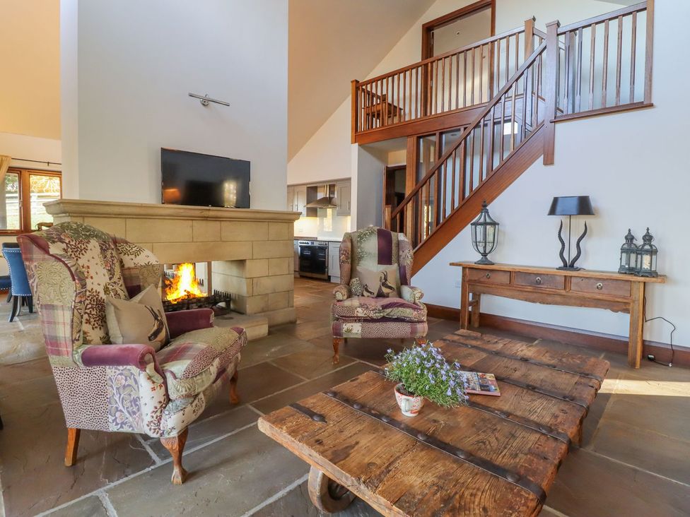 A living room with a fireplace and television at Sandy Gate in Knaresborough
