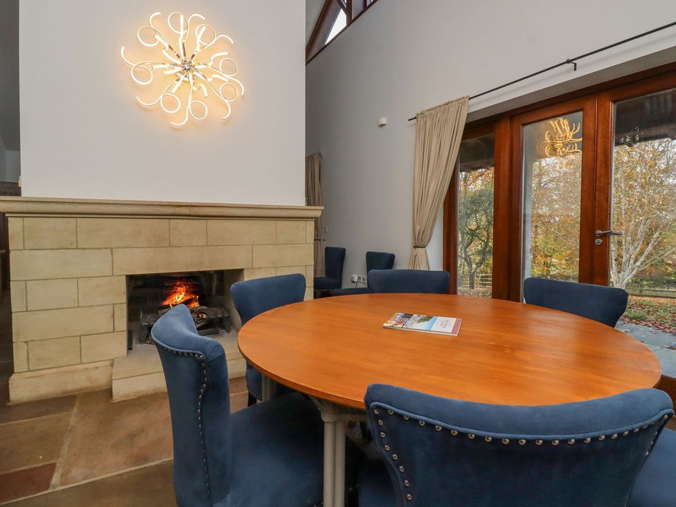 A dining room with a round table and chairs at Sandy Gate in Knaresborough