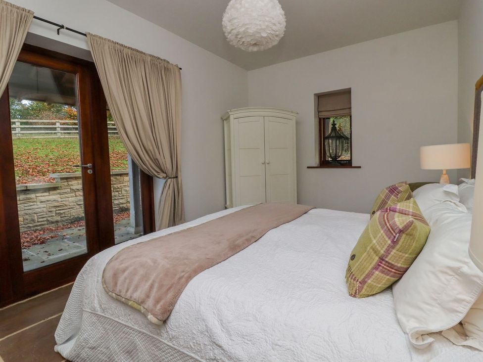 A bedroom with a bed and wardrobe at Sandy Gate in Knaresborough