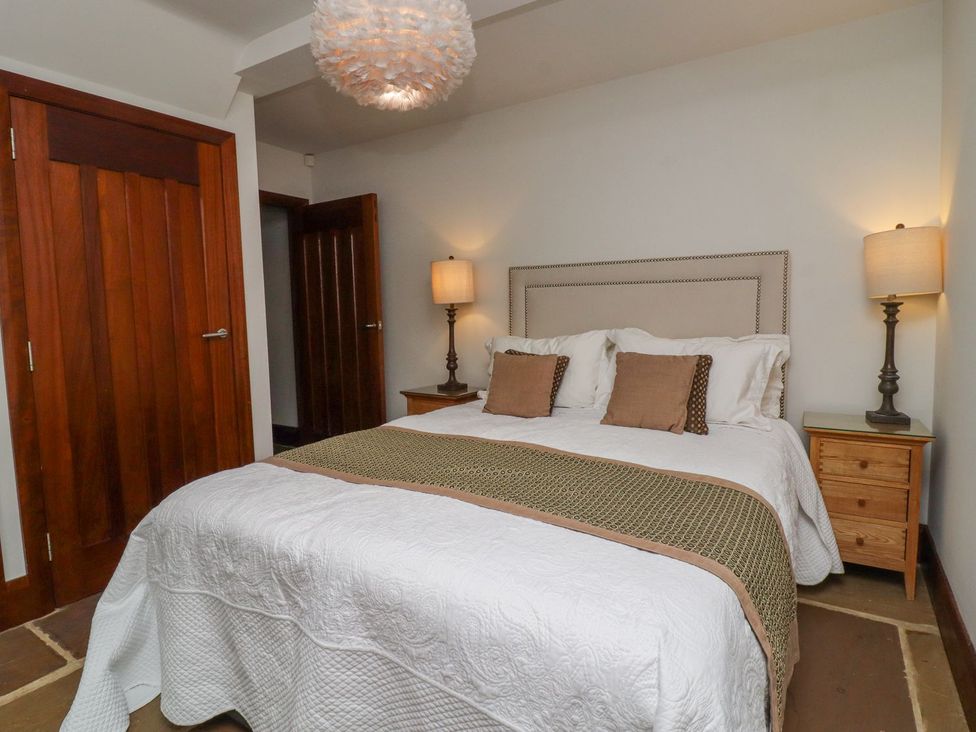A bedroom with a bed and bedside tables at Sandy Gate, Knaresborough