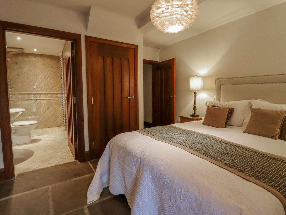 A bedroom with a bed and bathroom entrance at Sandy Gate in Knaresborough