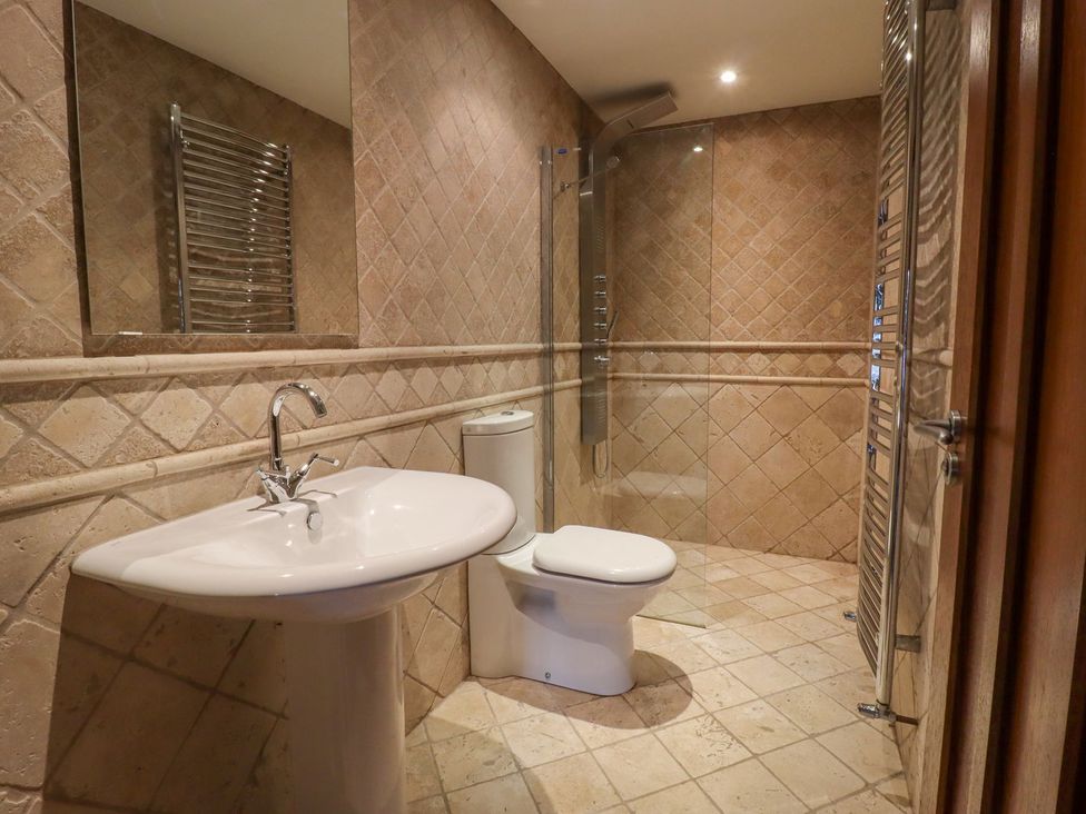 A bathroom with sink, toilet, shower and towel radiator at Sandy Gate in Knaresborough