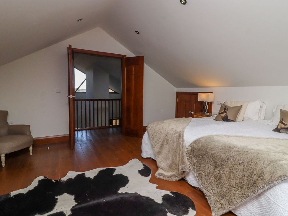 A bedroom with a bed and armchair at Sandy Gate in Knaresborough