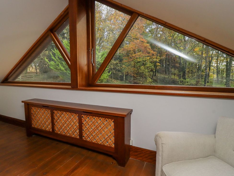 A living room with a wooden bench and large windows at Sandy Gate in Knaresborough