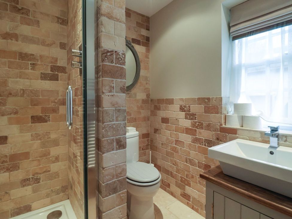 A bathroom with a shower, toilet, and sink at The Bothy in Knaresborough