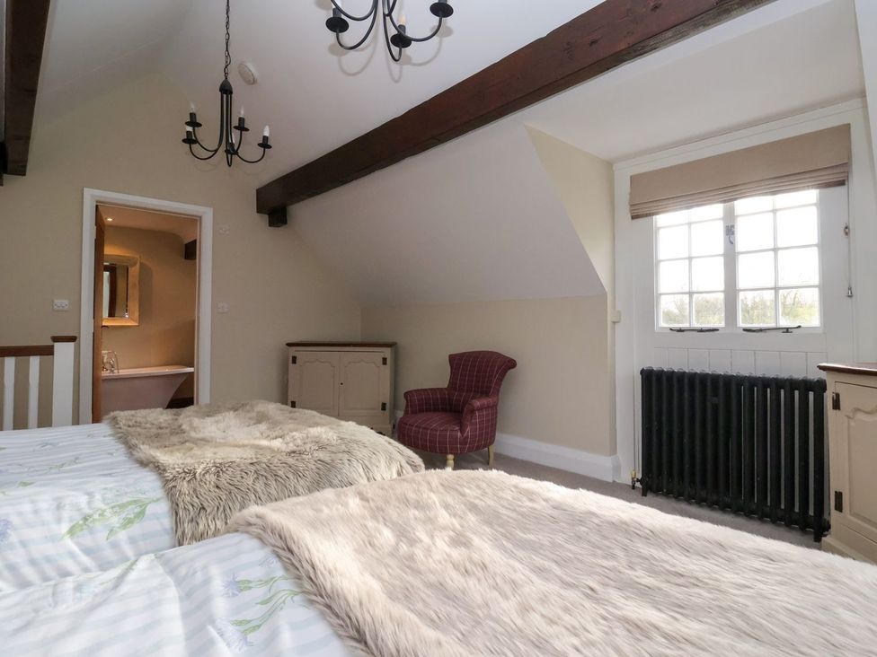 A bedroom with a bed and chair at The Bothy in Knaresborough