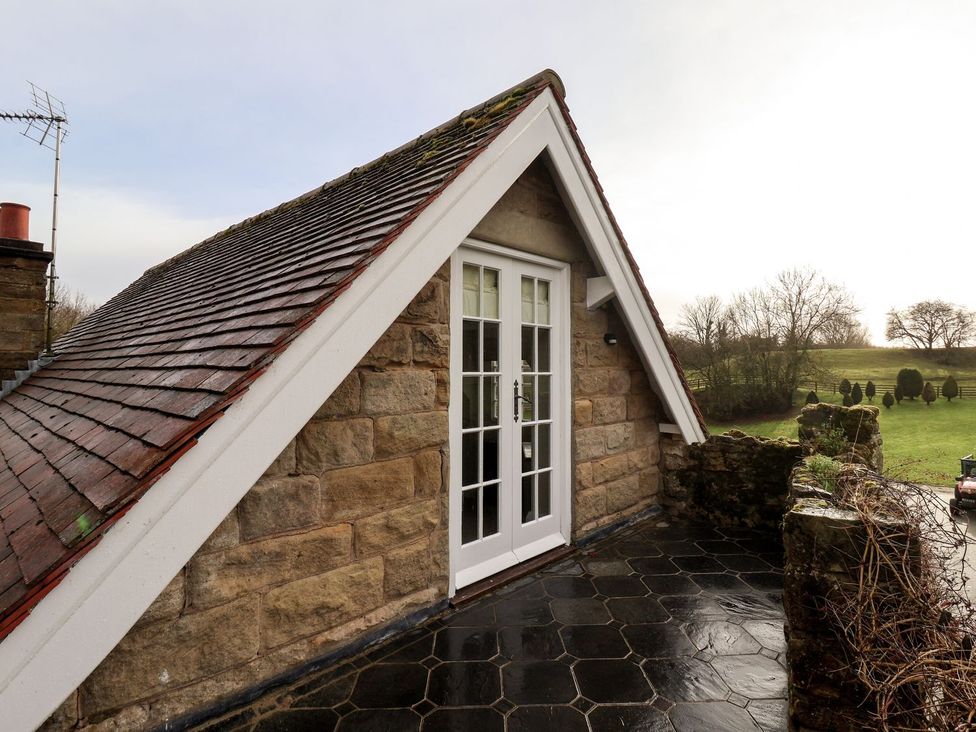 An outdoor area with a stone wall and door at The Bothy in Knaresborough