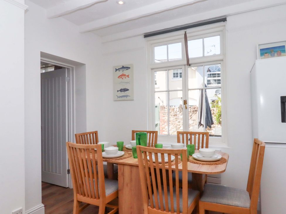 A dining room with a table and chairs at Kents Cottage in Torquay