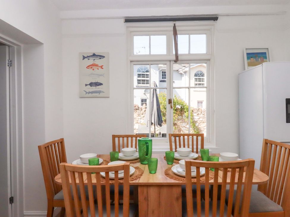 A dining room with a table set for meals at Kents Cottage in Torquay