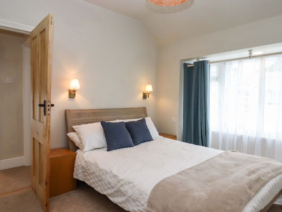 A bedroom with a bed and side tables at Kents Cottage in Torquay
