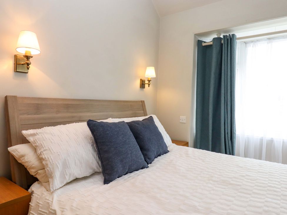 A bedroom with a bed and bedside lamps at Kents Cottage in Torquay