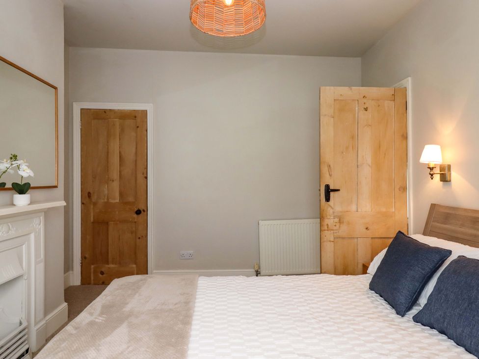 A bedroom with a bed and a lamp at Kents Cottage in Torquay