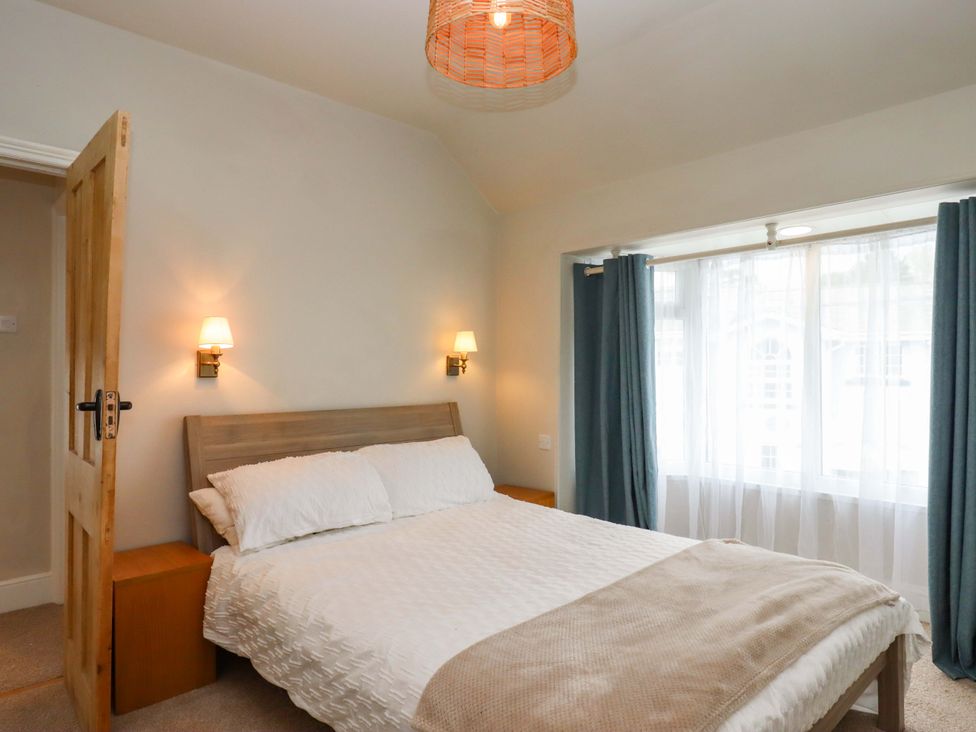 A bedroom with a bed and window at Kents Cottage in Torquay