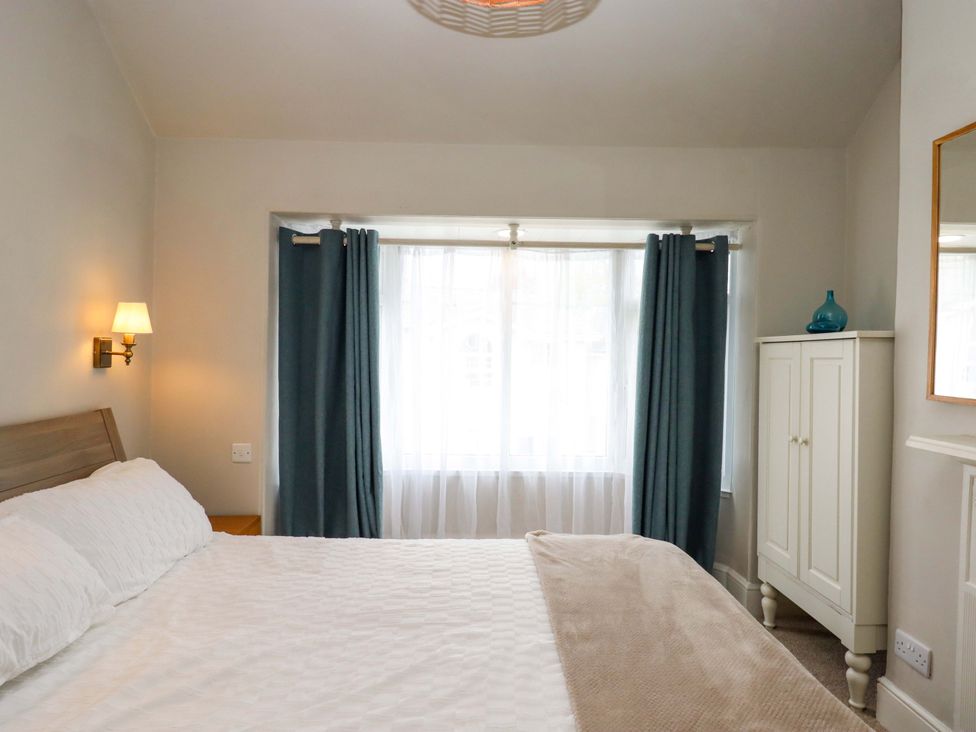A bedroom with a bed and window at Kents Cottage in Torquay