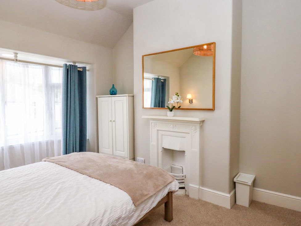 A bedroom with a bed and wardrobe at Kents Cottage in Torquay