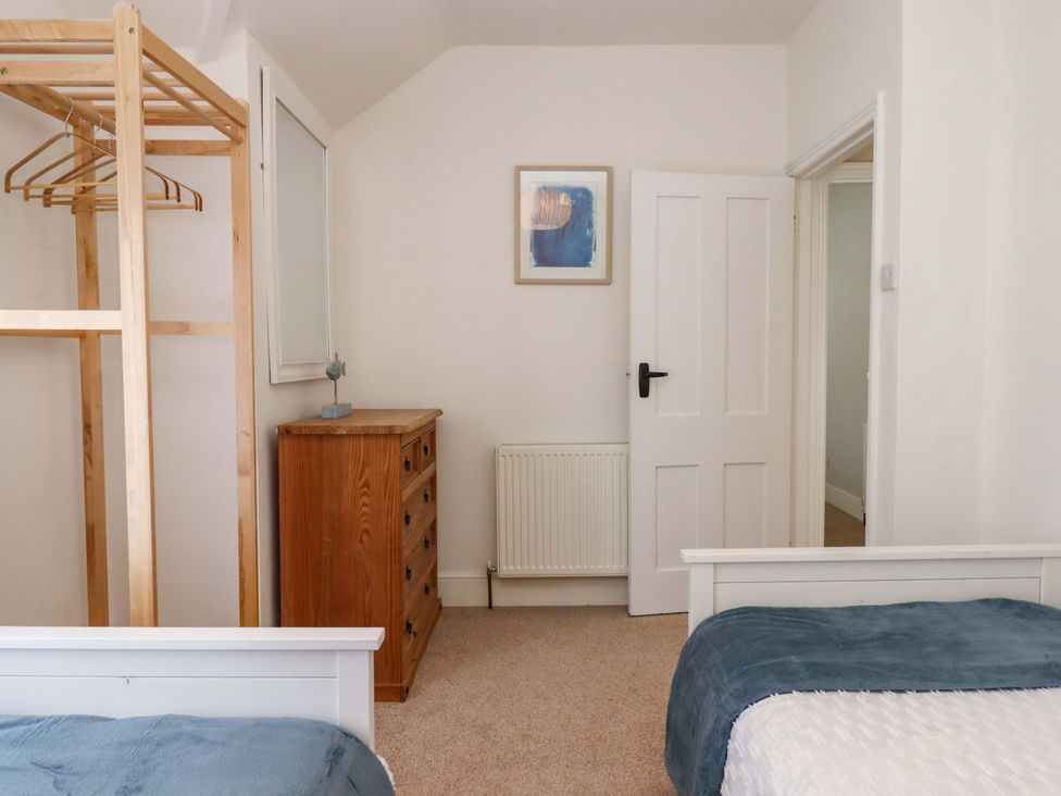 A bedroom with a clothes rack and a dresser at Kents Cottage in Torquay