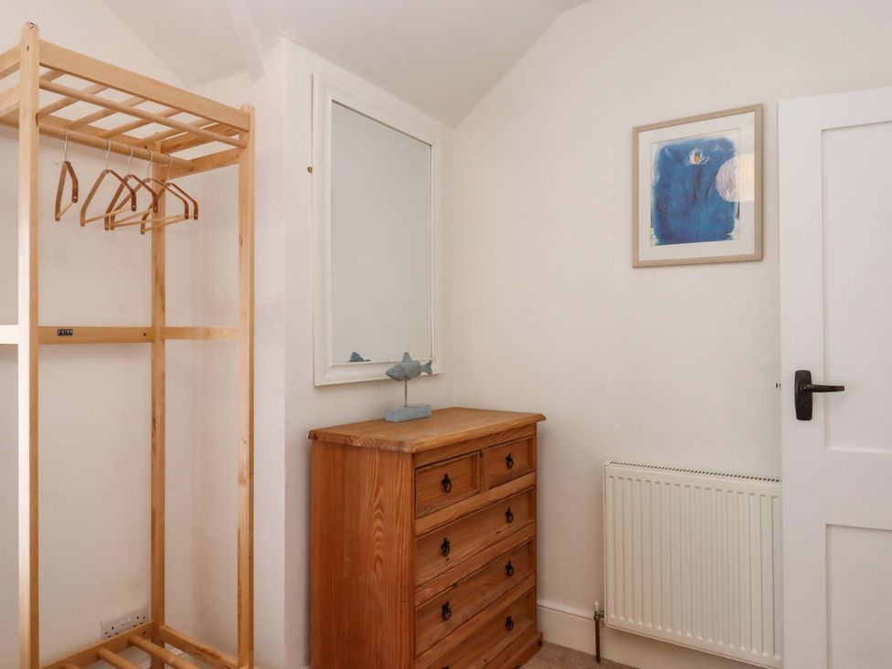 A bedroom with a clothes rail and a chest of drawers at Kents Cottage in Torquay