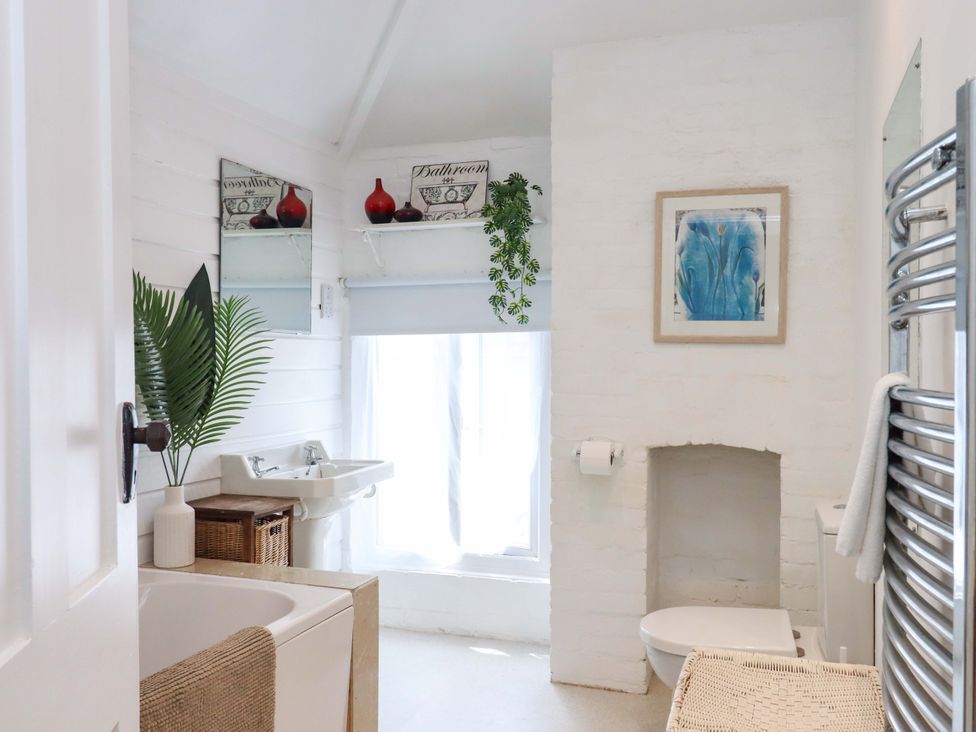 A bathroom with a bathtub, sink, and toilet at Kents Cottage in Torquay