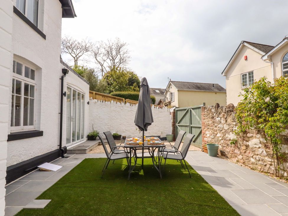 An outdoor dining area with a table and chairs at Kents Cottage in Torquay