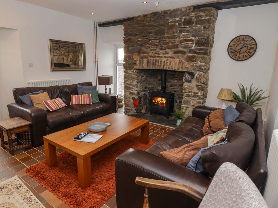 A living room with a fireplace and sofa at No.8 Millmoor Farm Cottage Broad Haven