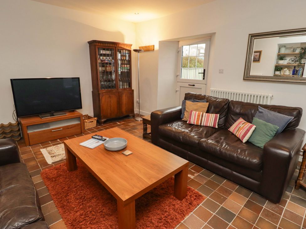 A living room with a television and a coffee table at No.8 Millmoor Farm Cottage in Broad Haven