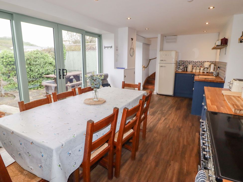 A kitchen with a dining table and refrigerator at No.8 Millmoor Farm Cottage Broad Haven