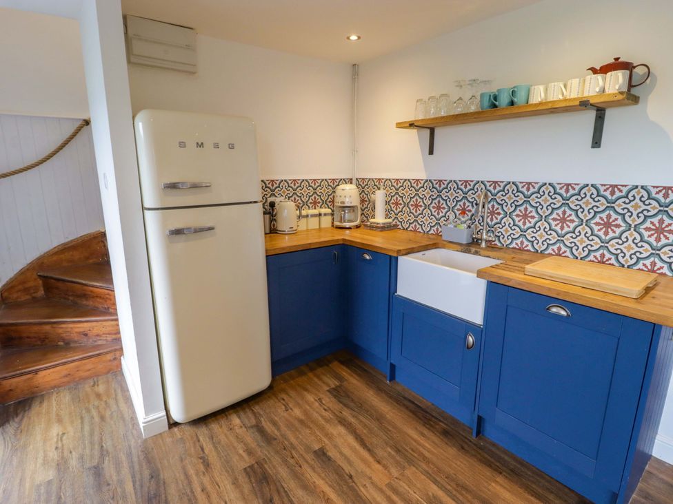 A kitchen with a fridge, sink, and countertop at No.8 Millmoor Farm Cottage in Broad Haven