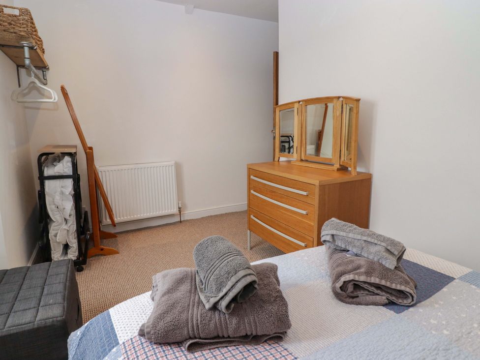 A bedroom with a bed and dresser at No.8 Millmoor Farm Cottage in Broad Haven