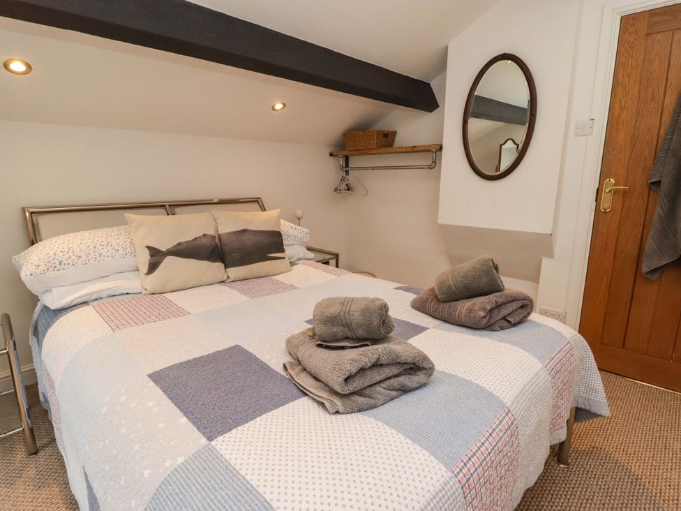 A bedroom with a bed and towels at No.8 Millmoor Farm Cottage in Broad Haven