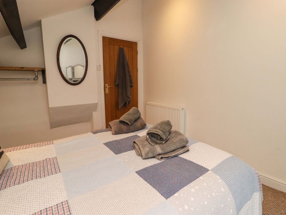 A bedroom with a bed and towels at No.8 Millmoor Farm Cottage in Broad Haven
