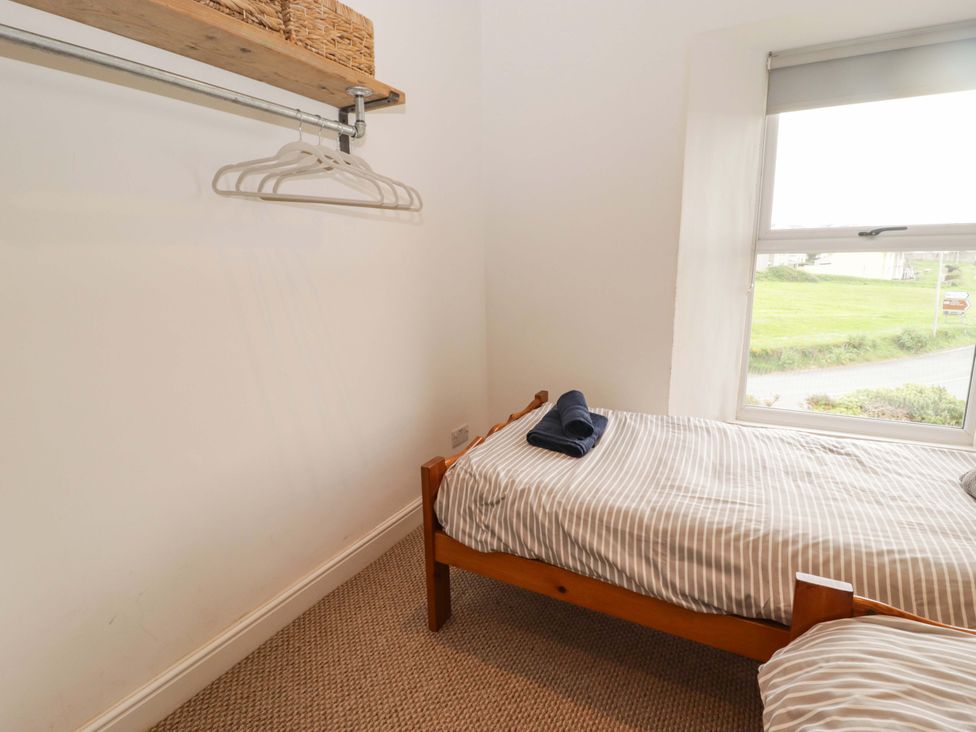 A bedroom with a single bed and shelf at No.8 Millmoor Farm Cottage in Broad Haven