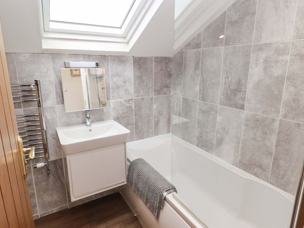 A bathroom with a bath tub and wash basin at No.8 Millmoor Farm Cottage in Broad Haven